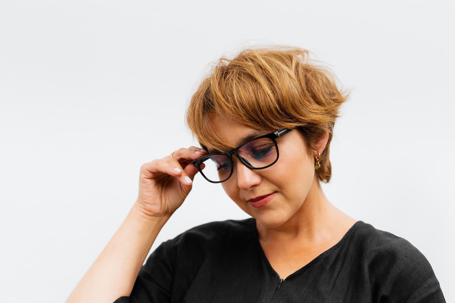 Close portrait of a woman wearing glasses against a white background