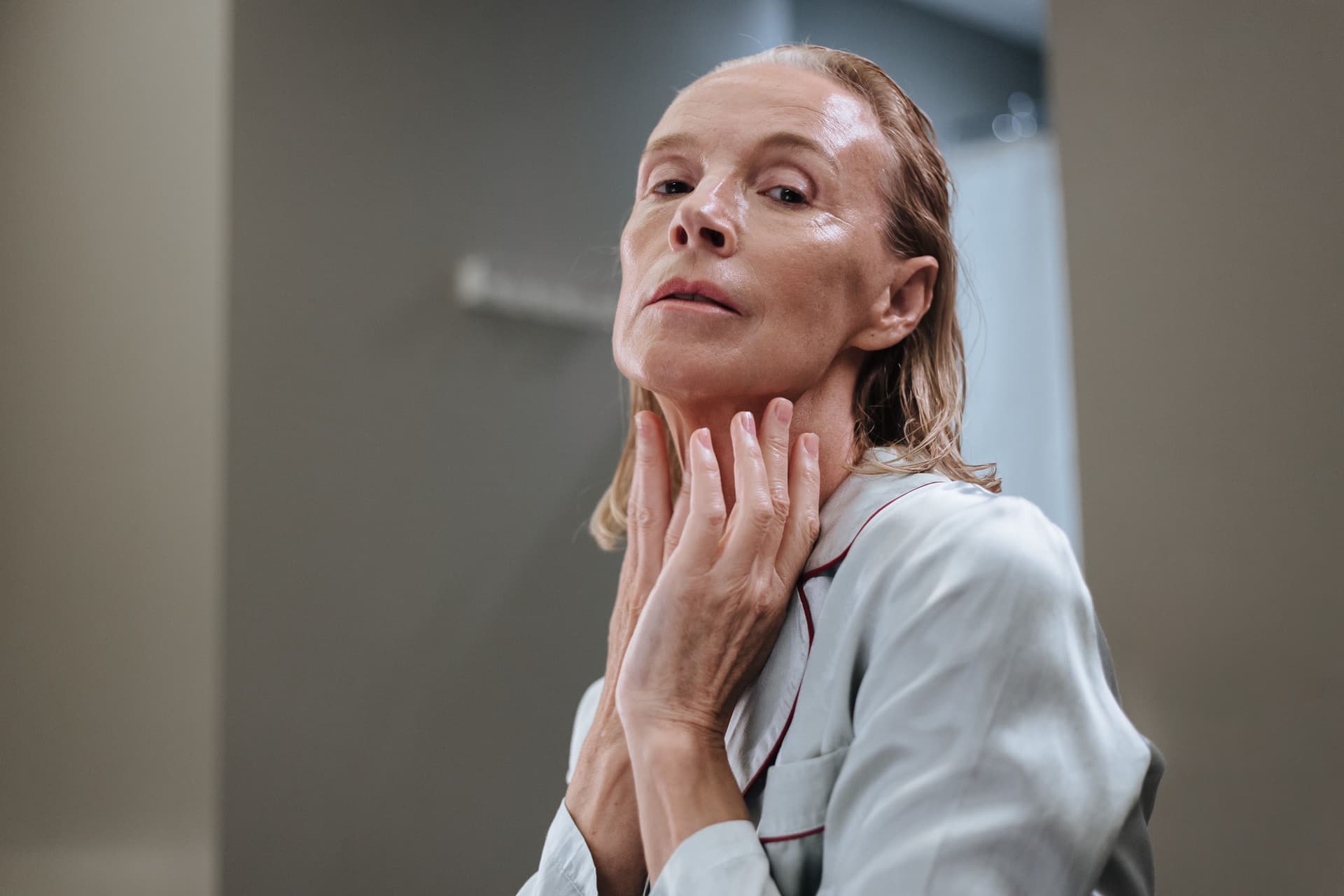 An older woman applying a skincare product to her face